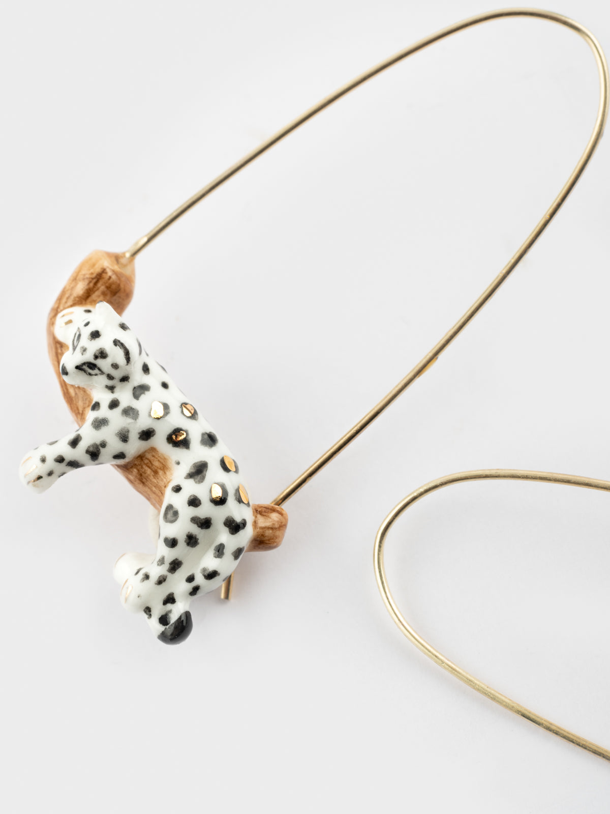 White leopard drop earrings on a branch