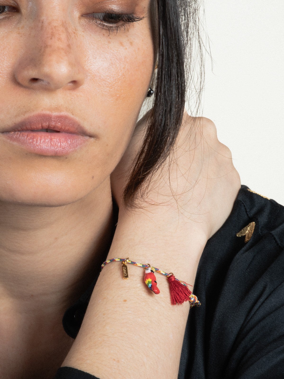 bracelet cordelette oiseau perroquet rouge avec pompon