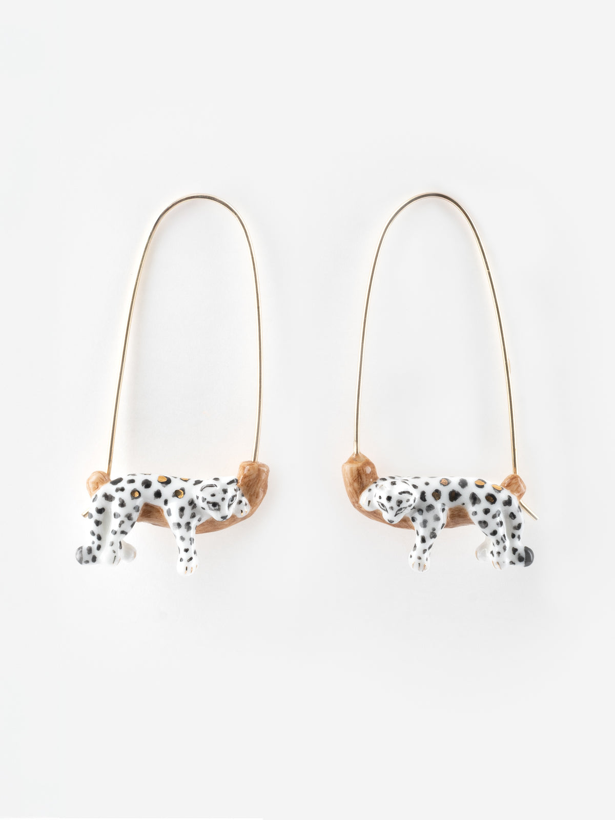 White leopard drop earrings on a branch