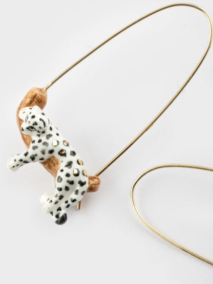 White leopard drop earrings on a branch