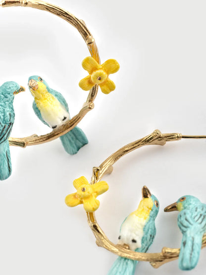 Orecchini a forma di ramo con inseparabili e narcisi